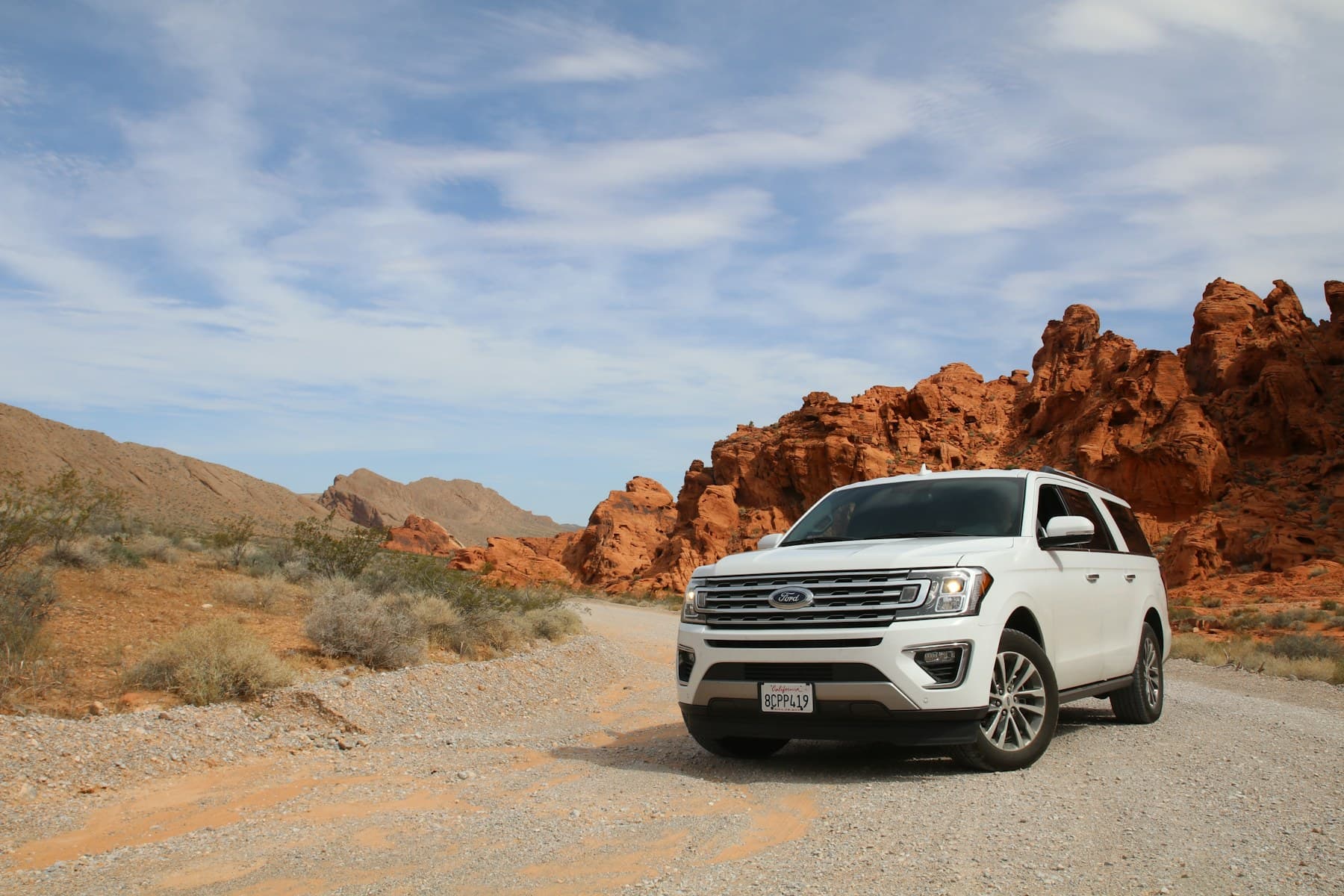 White SUV on a scenic road, used as an illustrative airport-transfer image