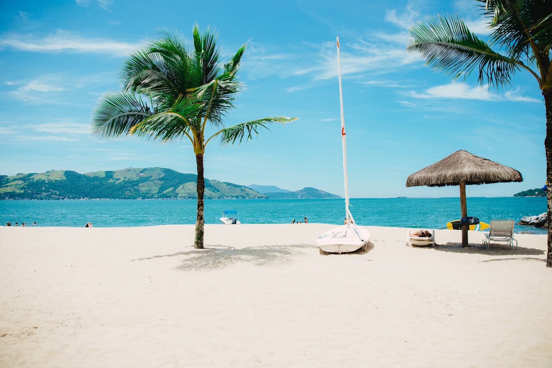 Palm-lined tropical beach and sailboat