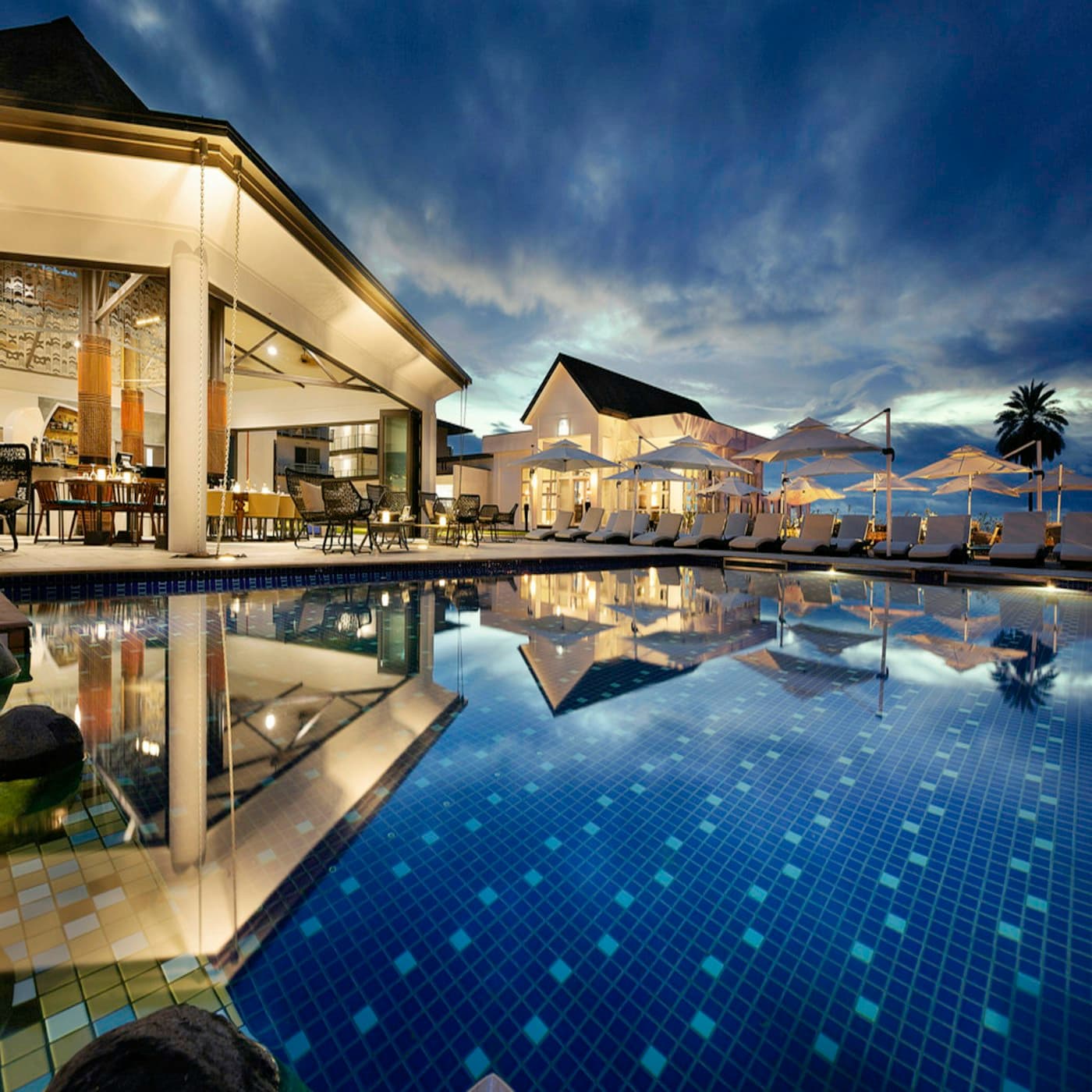 Tropical resort pool among green gardens